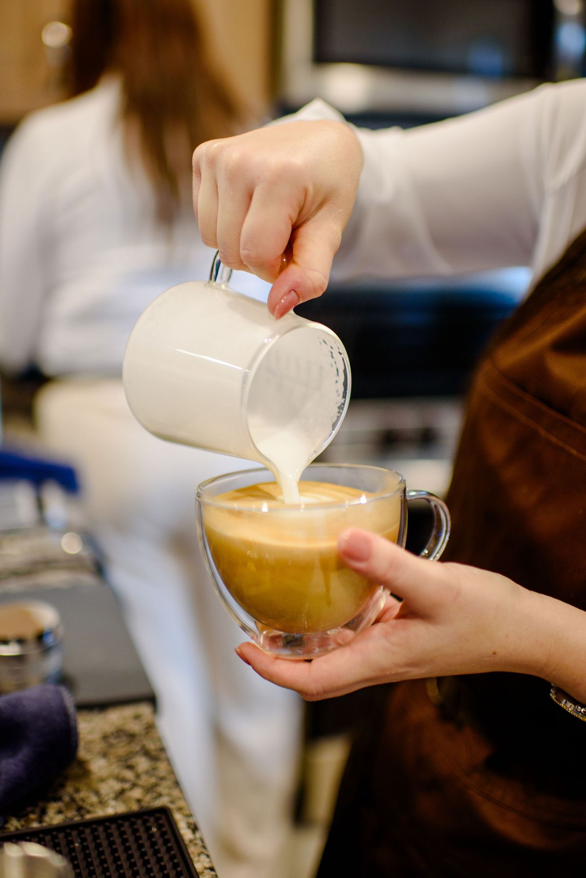 Pouring steamed milk into a latte